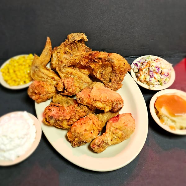 George's Family Restaurant's fried chicken platter with sides of corn, coleslaw, mashed potatoes, and cottage cheese.